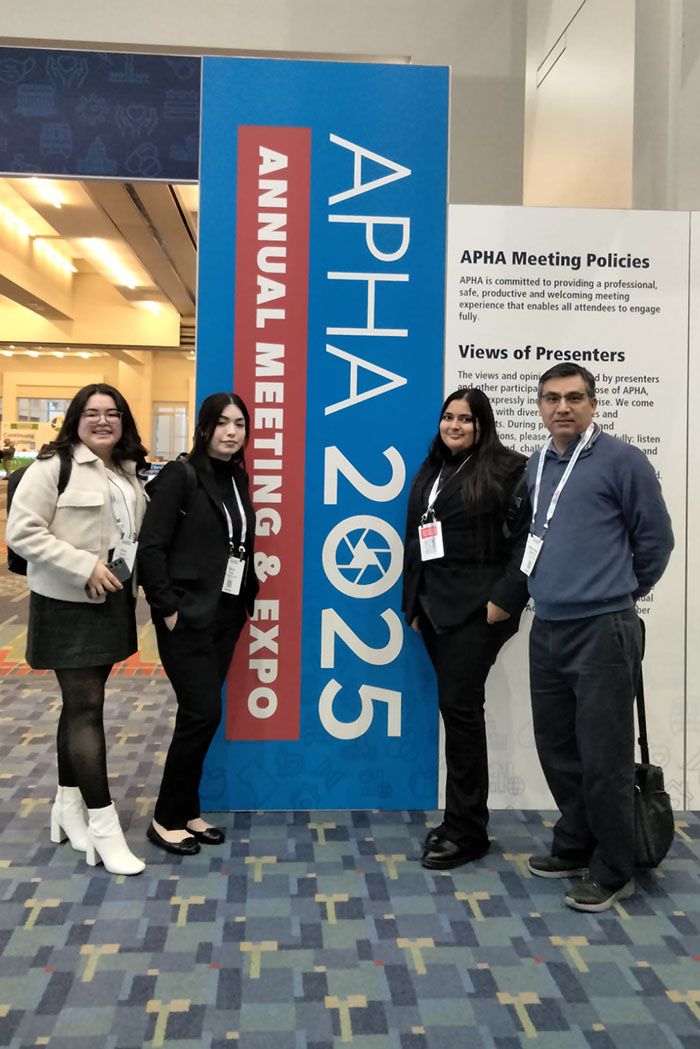 Four SDSU IVPRC team members pose next to a large APHA 2025 Annual Meeting & Expo sign inside the conference venue.