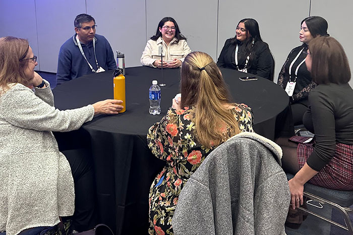 IVPRC team members and conference attendees seated around a table in active discussion during an APHA 2025 breakout session.